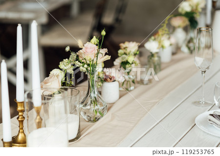 Elegant neutral coloured wedding table scape with flowers and candles 119253765