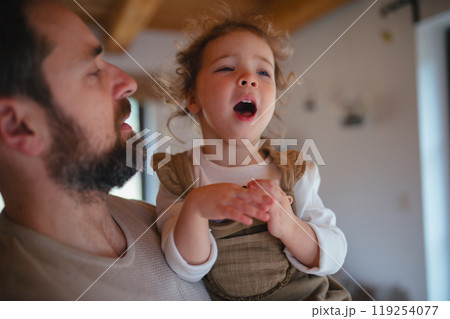 Sick girl with fever and cold at home. Father holding crying daughter. Sick girl with fever and cold at home. Father holding crying daughter. 119254077