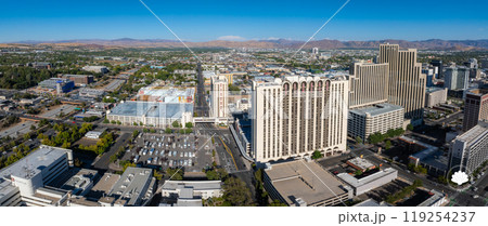 Aerial perspective of Reno, Nevada, featuring high rise buildings like Circus Circus, grid like streets, and the Sierra Nevada mountains in the background. 119254237