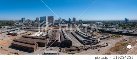 Aerial view of Sacramento, California, featuring historic industrial buildings, modern skyline, Sacramento River, and major highway under a clear blue sky. Aerial view of Sacramento, California, featuring historic industrial buildings, modern skyline, Sacramento River, and major highway under a clear blue sky. 119254253