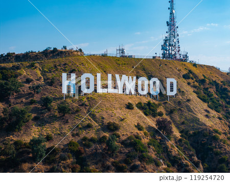 The Hollywood Sign's large white letters stand out on Mount Lee, Los Angeles, with a communications tower and clear sky in the background. The Hollywood Sign's large white letters stand out on Mount Lee, Los Angeles, with a communications tower and clear sky in the background. 119254720