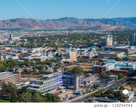 Aerial perspective of Reno, Nevada, highlighting urban structures and the Sierra Nevada mountains under a clear daytime sky, with visible urban development. 119254743
