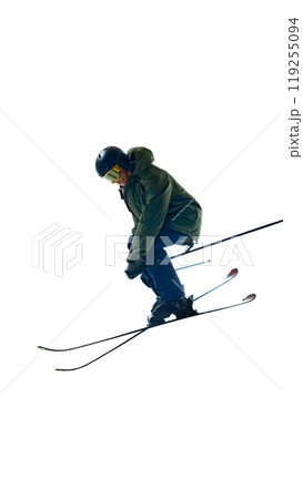 With skis crossed, skier reaches peak of jump, showing off advanced skill and athletic prowess. Moment feels frozen in time. 119255094