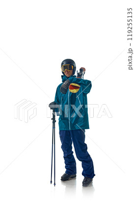 Skier dressed in teal gear stands confidently with his ski poles, ready for action against white studio background. He stares ahead, exuding focus and preparation. Skier dressed in teal gear stands confidently with his ski poles, ready for action against white studio background. He stares ahead, exuding focus and preparation. 119255135