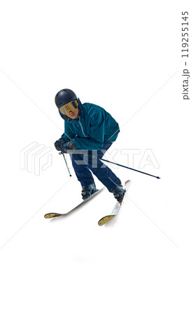 In full motion, skier leans into slope, poles angled for control against white studio background. Determination in his stance shows his dedication to sport. 119255145