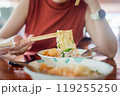 Woman hands holding delicious egg noodle with chopsticks 119255250