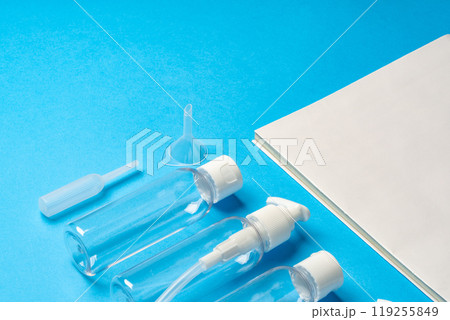 Various clear plastic bottles and containers arranged on a blue background Various clear plastic bottles and containers arranged on a blue background 119255849