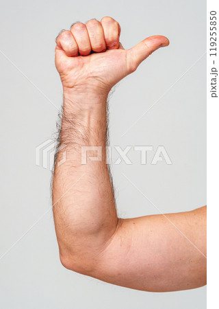 A hand giving a thumbs-up gesture against a neutral background A hand giving a thumbs-up gesture against a neutral background 119255850