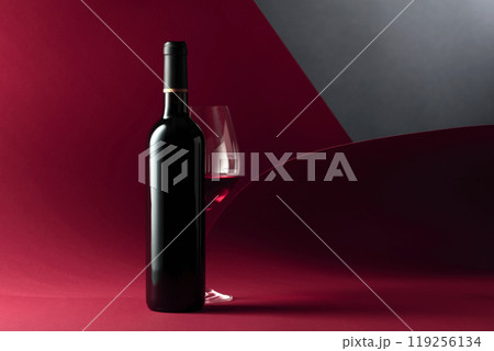 Bottle and glass of red wine. 119256134