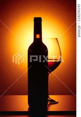 Bottle and glass of red wine. 119256145