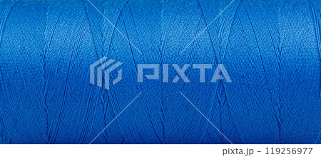 Texture of threads in a spool of blue color on a white background 119256977