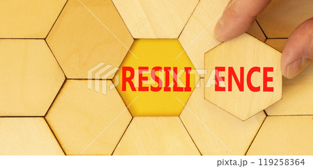 Resilience symbol. Concept word Resilience on beautiful wooden puzzles. Beautiful yellow background. Businessman hand. Business resilience concept. Copy space. 119258364