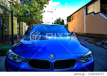 Beautiful blue BMW 4 series. Illustrative.  On a sunny day, along the fence on the street there is a blue car with folded mirrors. 119258727