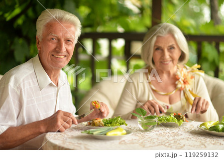 Happy senior couple having diner and posing at home Happy senior couple having diner and posing at home 119259132