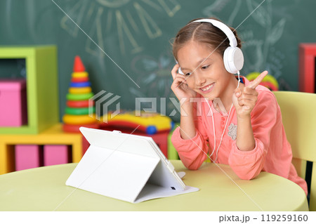 Cute little woman with tablet and headphones 119259160