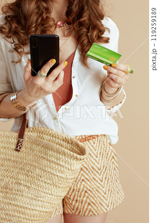 Stylish female in blouse and shorts isolated on beige 119259189