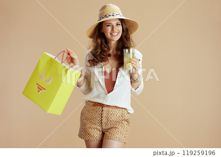 smiling stylish female in blouse and shorts isolated on beige smiling stylish female in blouse and shorts isolated on beige 119259196