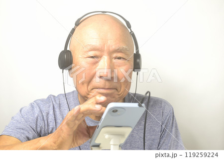 スマホで音楽を楽しむ笑顔の老人 119259224