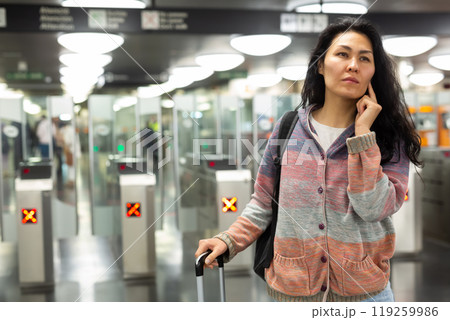 Asian woman passing through ticket gates in public transportation station 119259986