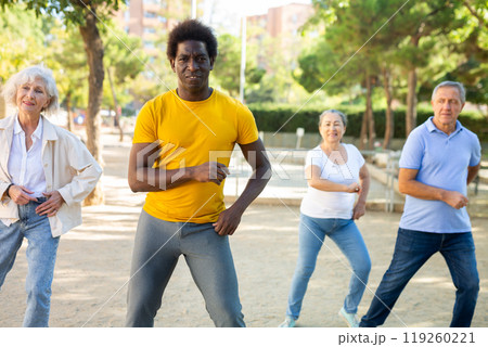 Group of multiracial friends getting together outdoors and dancing simple moves on a sunny day in autumn 119260221