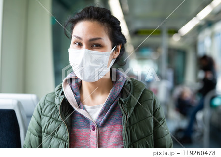 Woman in protective mask sitting in subway train Woman in protective mask sitting in subway train 119260478
