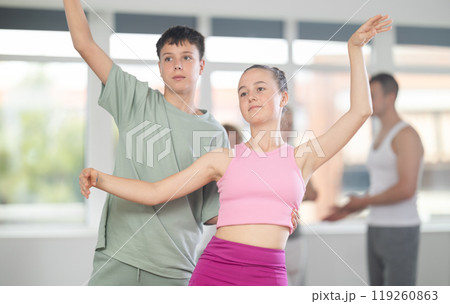 Boy and girl in pair train to perform ballet dance during rehearsal in studio 119260863