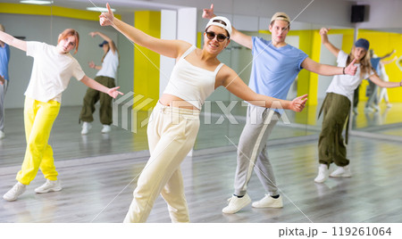 Young girl in sunglasses training breakdance Toprock moves in dance hall Young girl in sunglasses training breakdance Toprock moves in dance hall 119261064