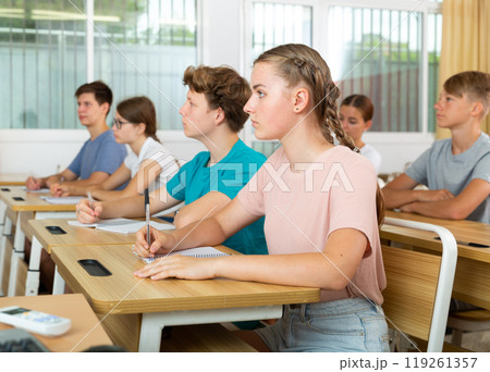 Teenager students sitting at desks Teenager students sitting at desks 119261357