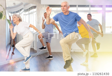 Elderly man learning dynamic dances at group choreography lesson 119261430