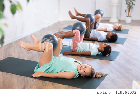 Girl participates in group lesson with softball, modern sport in studio. 119261932