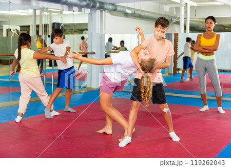 Kids in pair exercising self-defense movements Kids in pair exercising self-defense movements 119262043