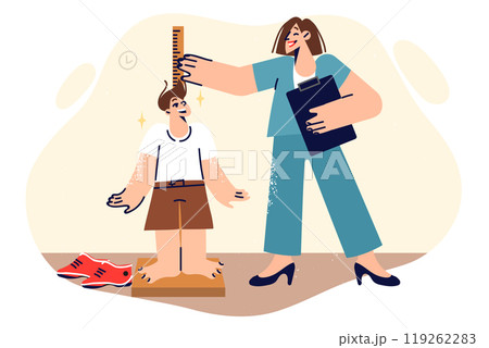 Woman pediatrician measures height of little boy and smiles, enjoying work in children clinic 119262283