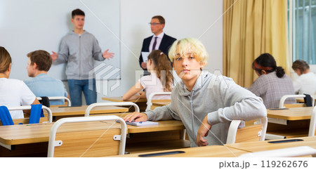 Young teenager is sitting at the desk in classroom Young teenager is sitting at the desk in classroom 119262676