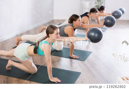 Girl participates in group lesson with sof tball, modern sport in studio. Girl participates in group lesson with sof tball, modern sport in studio. 119262802