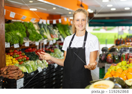 Portrait of a smiling girl who works part-time in a store as a trainee saleswoman 119262868