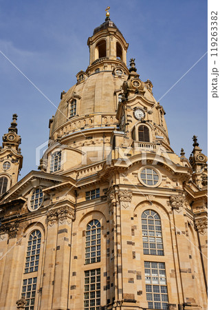 Buiilding exterior of Dresden Frauenkirche. Baroque architecture with stonework, large arched windows and grand dome under a clear sky Buiilding exterior of Dresden Frauenkirche. Baroque architecture with stonework, large arched windows and grand dome under a clear sky 119263382