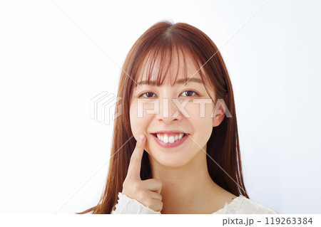口元を笑顔で指さす女性 口元を笑顔で指さす女性 119263384