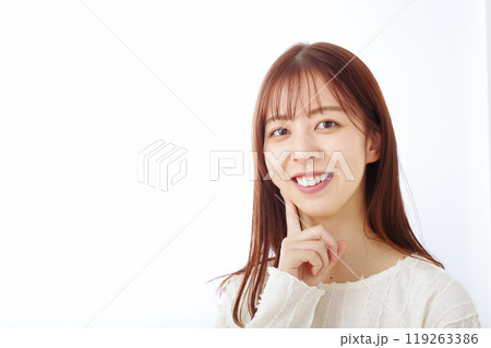 口元を笑顔で指さす女性 119263386