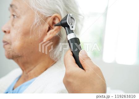 Otolaryngologist or ENT physician doctor examining senior patient ear with otoscope, hearing loss problem. Otolaryngologist or ENT physician doctor examining senior patient ear with otoscope, hearing loss problem. 119263810