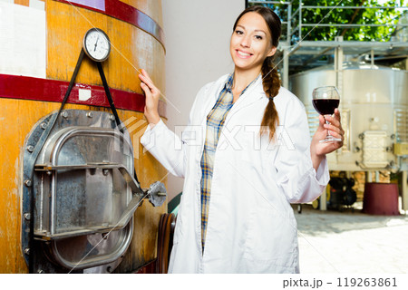 Female employee in white robe posing at winery Female employee in white robe posing at winery 119263861