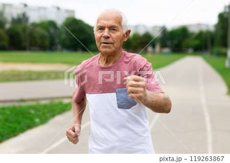 Elderly man with grey hair running in the park Elderly man with grey hair running in the park 119263867