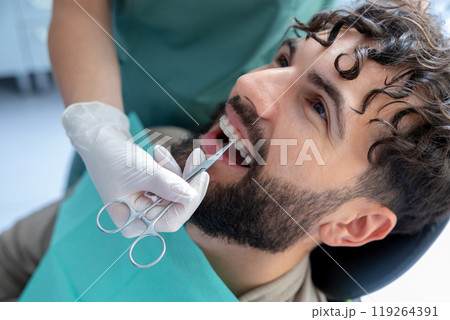 Dentist doing oral examination on patient with equipment to promote safety and hygiene 119264391