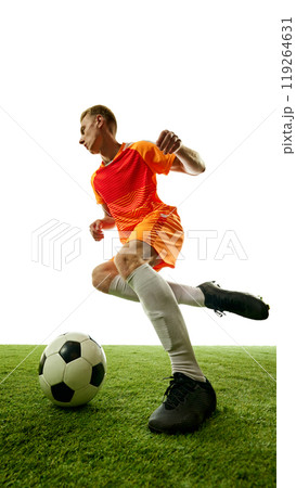 In motion, football player controls ball with expert precision, navigating green field in graceful athletic stance, ready to make next move. In motion, football player controls ball with expert precision, navigating green field in graceful athletic stance, ready to make next move. 119264631
