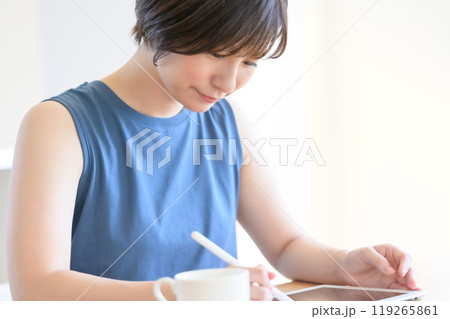 タッチペンを手にタブレット端末を操作する女性 119265861