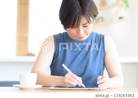 タッチペンを手にタブレット端末を操作する女性 タッチペンを手にタブレット端末を操作する女性 119265862