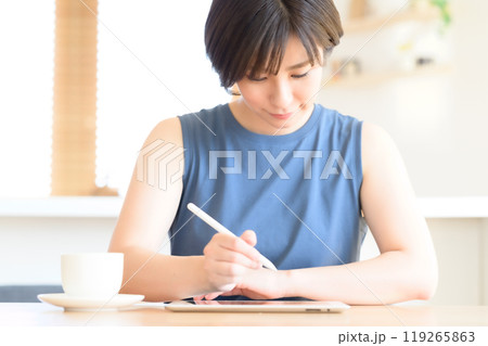 タッチペンを手にタブレット端末を操作する女性 タッチペンを手にタブレット端末を操作する女性 119265863