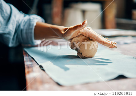 Female potter sculpts from clay at her workshop close-up 119265913