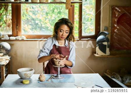 Female artist sculpts crafts with ceramic clay at her creative workshop 119265931