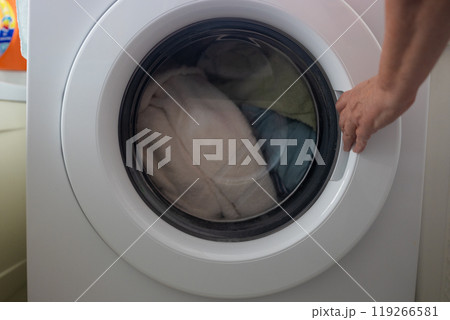 Woman's hand pick up clothes washing machine. Clean and healthy concept Woman's hand pick up clothes washing machine. Clean and healthy concept 119266581