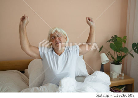 Portrait of beauty Caucasian 50s 60s woman awaking, wake up on the bed. Young beautiful female stretching her arms in fresh early morning, relax peaceful morning routine yawn concept banner 119266608
